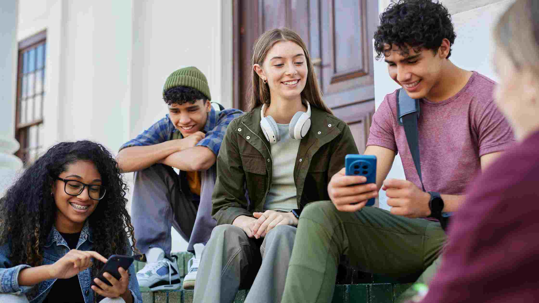 Students on campus steps see information on their phones, representing the step-by-step Duke University admissions process.