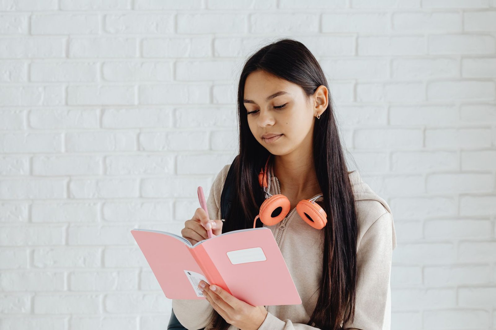 Student writing reflectively in a journal at a desk