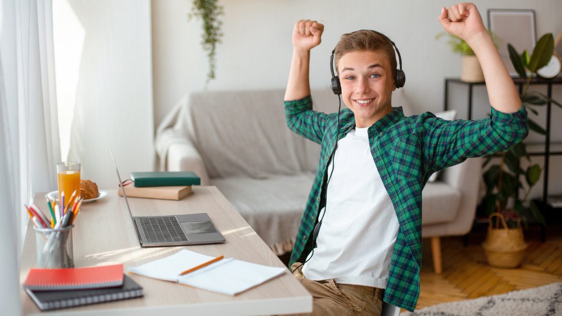 Student raising arms at desk symbolizing SAT test length 2026, total testing time, digital pacing, and break structure.