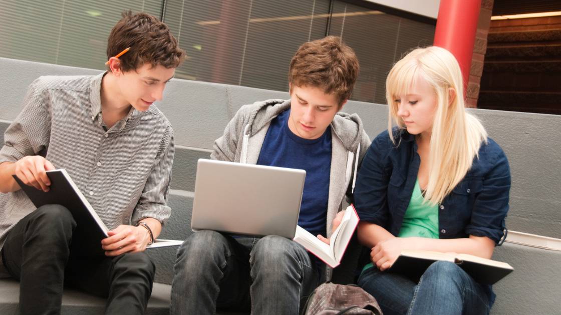 Students checking SAT scores online together, showing how to check your SAT scores when they're released digitally.