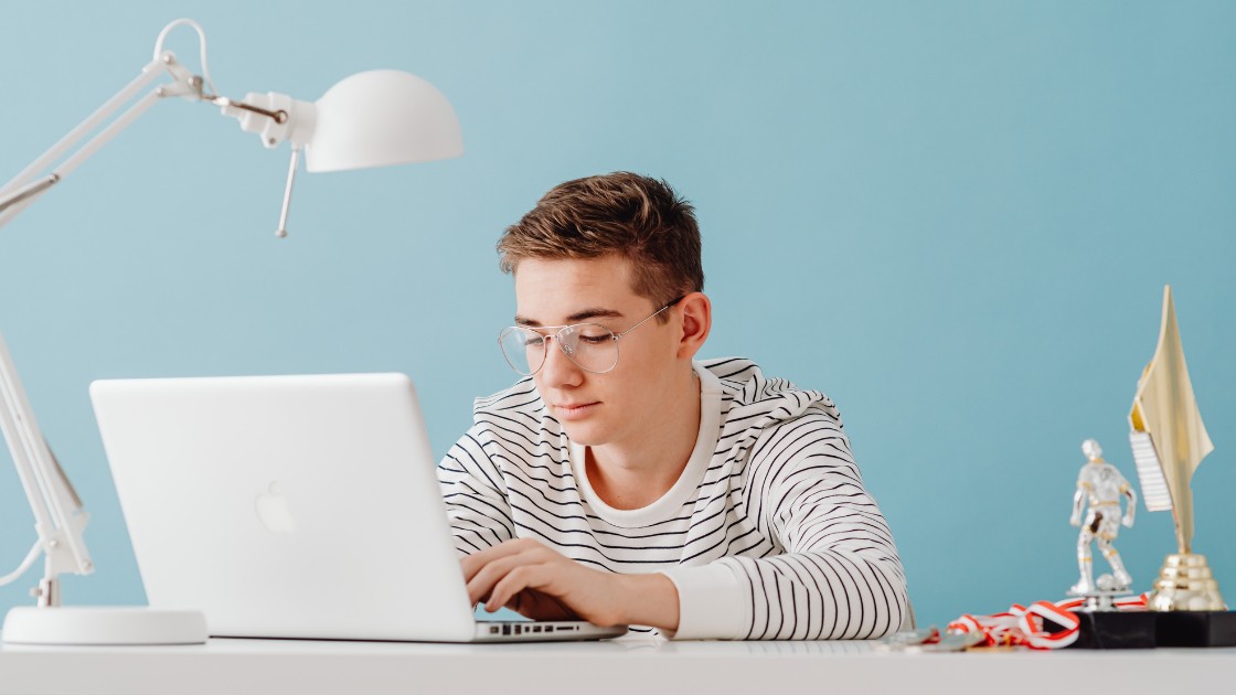 Teen student using laptop at home illustrating how long for SAT scores, showing the typical score wait time of 10 to 19 days.